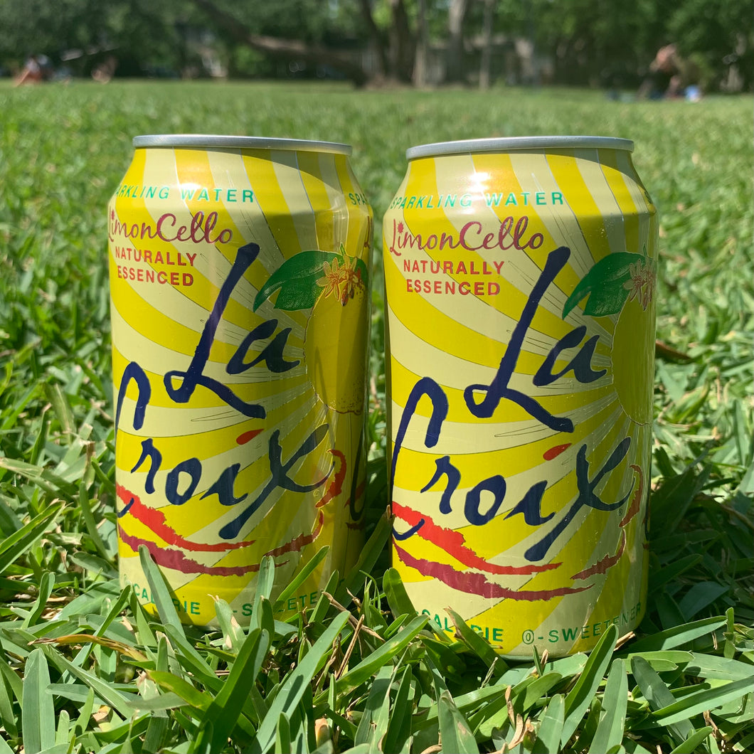 Two cans of lemoncello La Croix sparkling water in green grass.